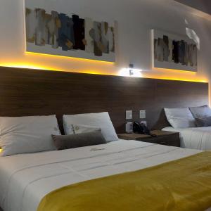 Cette chambre d'hôtel comprend 2 lits avec des oreillers blancs. dans l'établissement Hotel StayHome, à Ensenada