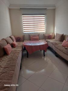- un salon avec un canapé et une table dans l'établissement Begoniâ house, à Agadir