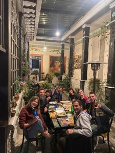 een groep mensen die rond een tafel zitten bij Villa Bonita Hostel in Riobamba