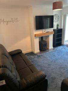 a living room with a couch and a flat screen tv at Morganvilla! in Chatham