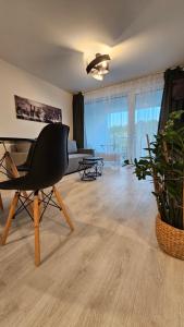 uma sala de estar com uma cadeira preta e um sofá em 2 room Apartment with terrace, 2AK em Bratislava