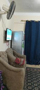 a living room with a couch and a tv at الساحل الشمالي in El Alamein