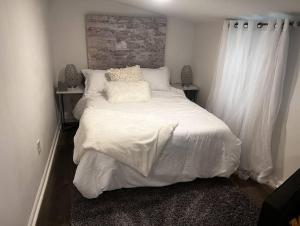 sypialnia z dużym łóżkiem z białą pościelą w obiekcie The Double Door Inn - Unit 2 w mieście Matthews