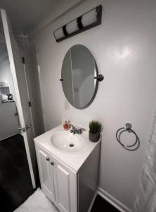 W białej łazience znajduje się umywalka i lustro. w obiekcie The Double Door Inn - Unit 2 w mieście Matthews
