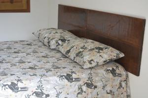 uma cama com duas almofadas em cima em Pousada Luz da Vila Itaúnas em Itaúnas