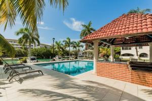 a swimming pool with a gazebo and palm trees at Stylish Lagoon front Villa by Casa Paraiso in Cancún