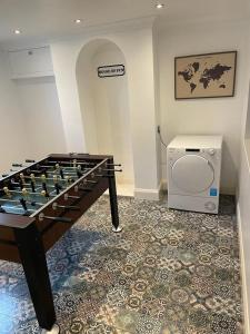 een kamer met een tafelvoetbaltafel voor een wasmachine bij Morganvilla! in Chatham