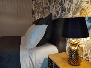 Cama con almohadas negras y mesa con lámpara en Apartamento Suite 48- Recién reformado en Avilés