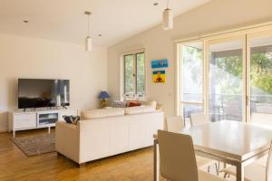 een woonkamer met een witte bank en een tafel bij One Level at Broadbeach Inverloch in Inverloch