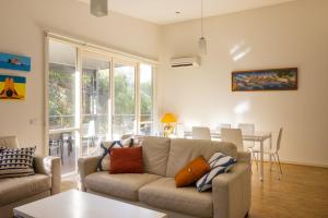 a living room with a couch and a table at One Level at Broadbeach Inverloch in Inverloch
