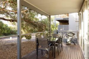 a screened porch with a table and chairs on it at One Level at Broadbeach Inverloch in Inverloch
