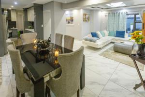 een keuken en een woonkamer met een tafel en stoelen bij Cozier Glitz in Kaapstad