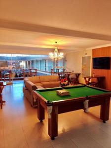 a living room with a pool table and a couch at Hotel Águas Virtuosas in Lambari