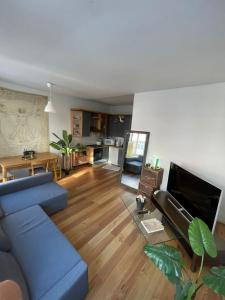 a living room with a blue couch and a kitchen at Appartement spacieux pour un séjour inoubliable in Brussels