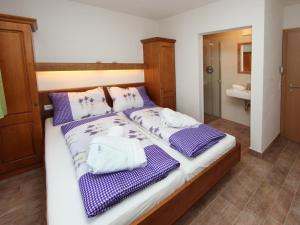 a bed with purple and white towels on it at Chalet Vorderjausern in Saalbach-Hinterglemm