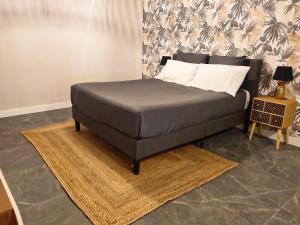 a bed sitting in a room with a rug at Apartamento Suite 48- Recién reformado in Avilés