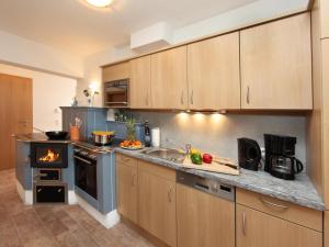 a kitchen with wooden cabinets and a stove top oven at Zirmblick in Saalbach Hinterglemm