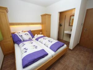 a bedroom with a bed with purple and white pillows at Zirmblick in Saalbach-Hinterglemm