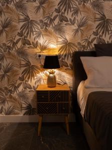 een lamp op een nachtkastje naast een bed bij Apartamento Suite 48- Recién reformado in Avilés