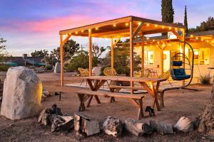 a picnic table with a pavilion and a swing at Dez-Art Retreat in Yucca Valley