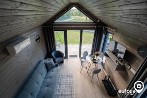 ein Wohnzimmer mit einem Sofa und einem Tisch in der Unterkunft Euforia Górzno - nowoczesne, klimatyzowane domki z jacuzzi i sauną in Górzno