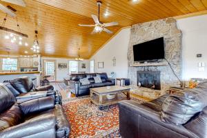 a living room with leather furniture and a stone fireplace at The Gathering Place in Sevierville
