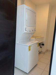 einen weißen Kühlschrank mit einem Wasserspender darüber in der Unterkunft Para sentirse en casa in Heredia