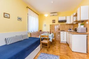 a small room with a bed and a kitchen at Apartments with a parking space Njivice, Krk - 5325 in Njivice