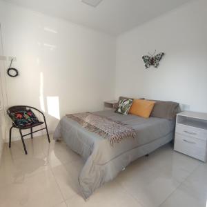 a bedroom with a bed and a chair in it at Villa Sarita 3D in Posadas