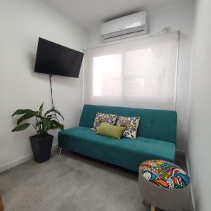 Villa Sarita 3D في بوساداس: غرفة معيشة مع أريكة خضراء ونافذة