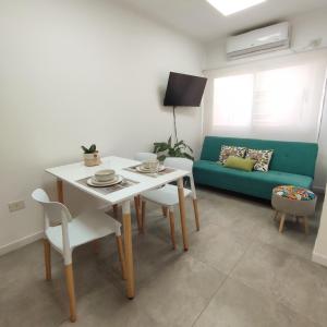 uma sala de estar com uma mesa e um sofá verde em Villa Sarita 3D em Posadas
