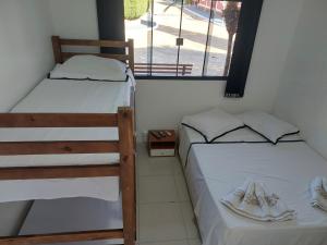 two bunk beds in a room with a window at Pousada Recanto Paraíso Família in Caldas Novas