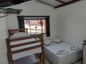 two bunk beds in a room with a window at Pousada Recanto Paraíso Família in Caldas Novas