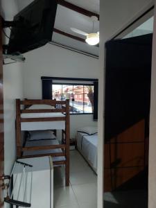 a room with a bedroom and a bed and a window at Pousada Recanto Paraíso Família in Caldas Novas