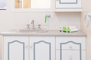 ein Badezimmer mit weißen Schränken und einem Waschbecken in der Unterkunft Beachfront Bliss- Aldinga Beach House - 5 BR in Aldinga Beach + 31 Fotos