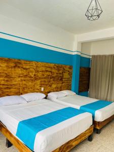 two beds sitting next to each other in a bedroom at Hotel Lu Acapulco in Acapulco