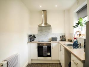 a kitchen with a stove and a sink at Home in Speke- 8 mins walk to airport in Speke