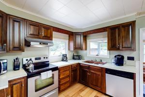 a kitchen with wooden cabinets and white appliances at Shady Acres in North Creek +13 photos