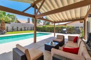 an outdoor patio with a pool and a pergola at Port Royal Retreat in Bermuda Dunes