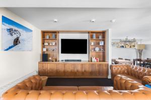 a living room with a couch and a television at Kooloora Lodge in Perisher Valley