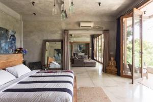 a bedroom with a bed and a living room at RiverView Gardens in Ubud