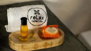 a bottle of oil on a wooden tray next to a towel at relax hotelito in Cárdenas