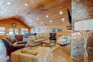 a living room with couches and a stone fireplace at Executive Cabin in Bentonville
