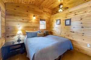 ein Schlafzimmer mit einem Bett in einer Holzhütte in der Unterkunft Cabin 1 & 2 in Bentonville