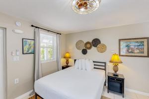 1 dormitorio con 1 cama blanca y 2 lámparas en Tiki Room en Marathon