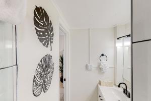 een badkamer met zwarte en witte bladeren aan de muur bij Tiki Room in Marathon