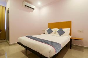 a bedroom with a large bed with a wooden headboard at Townhouse Rcc Premier Sr Nagar in Hyderabad