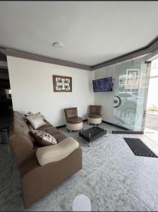 uma sala de estar com um sofá e duas cadeiras em Hotel Estambul em Dosquebradas
