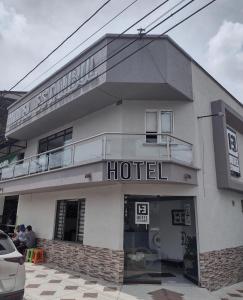 a hotel building with people sitting outside of it at Hotel Estambul in Dosquebradas