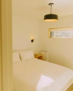 um quarto com uma cama branca e uma luz em Colorado Lodge em Big Bear Lake